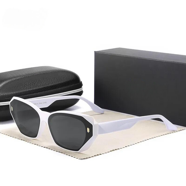 White-framed polarized sunglasses with dark lenses are displayed on a cloth next to a black hard case and a black rectangular box, all set against a plain white background.