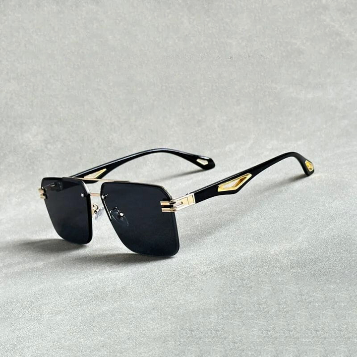 Black rectangular sunglasses with gold accents on the hinges and temples, featuring scratch resistant lenses, placed on a light grey surface.