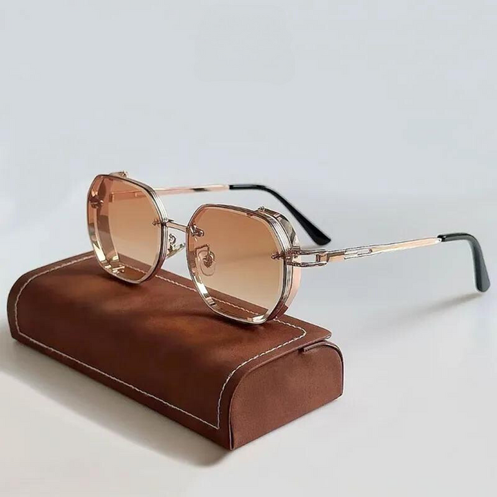 A pair of stylish, limited-edition eyewear featuring geometric-shaped, oversized frames with rose-tinted lenses and metallic detailing rests on a brown leather-textured case against a plain background.