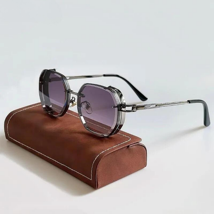 A pair of octagonal, silver-framed eclectic sunglasses with dark tinted lenses and oversized frames rests on a brown, rectangular eyeglass case with white stitching, set against a plain light background.