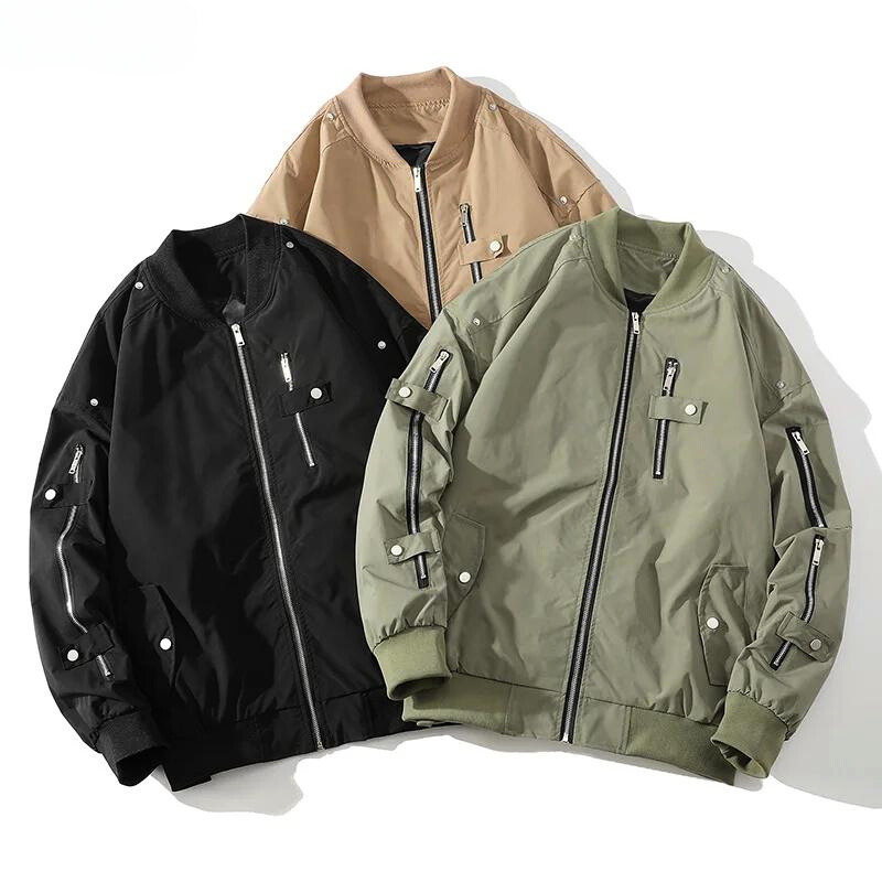 Three bomber jackets are laid out side by side in black, beige, and olive green. Each classic design features zippered pockets, snap buttons, and a ribbed collar with matching ribbed cuffs.