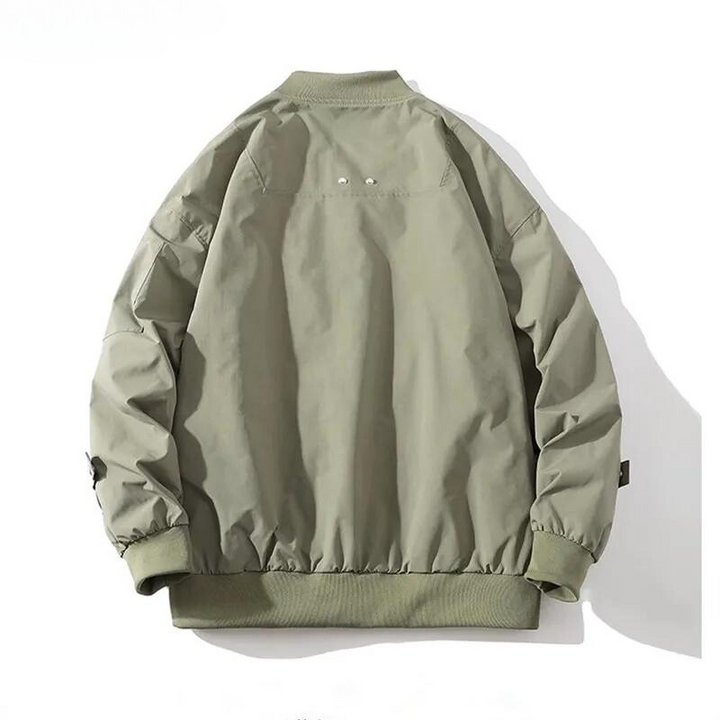 A light olive green bomber jacket is shown from the back. Featuring a classic design with ribbed collar, cuffs, and waistband, it has a relaxed fit with slight gathering at the hem and wrists. The jacket is displayed against a white background.