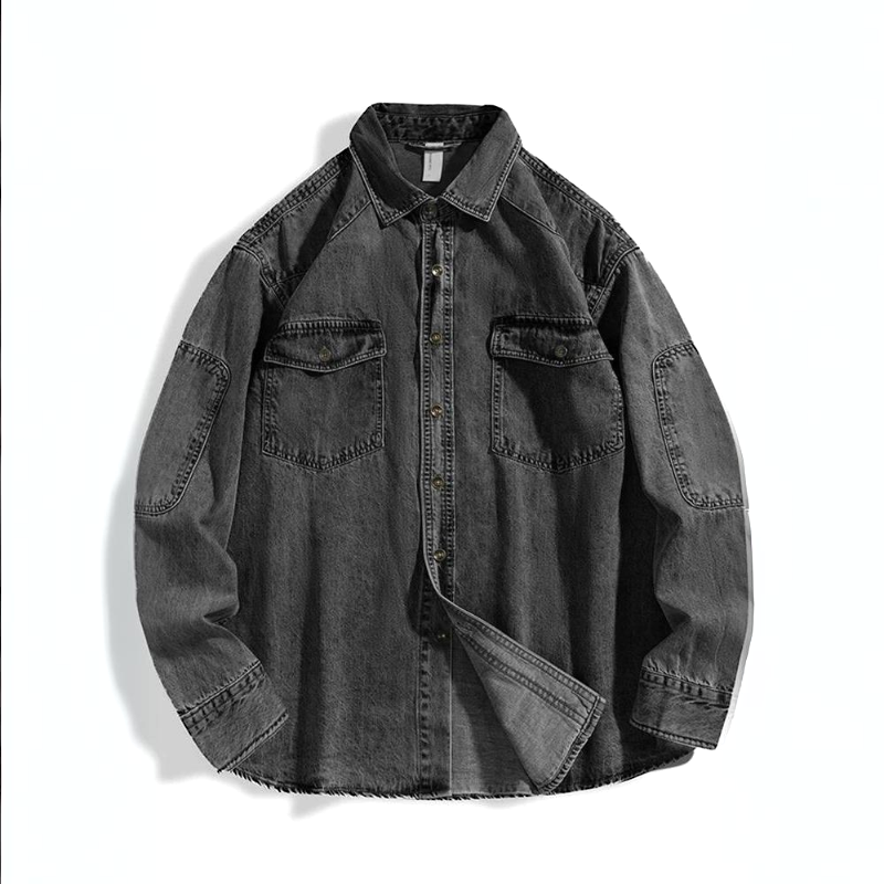 A rugged denim shirt in black pure cotton, featuring a button-up front, two chest pockets, visible stitching, long sleeves, and a classic collar, laid flat on a white background.