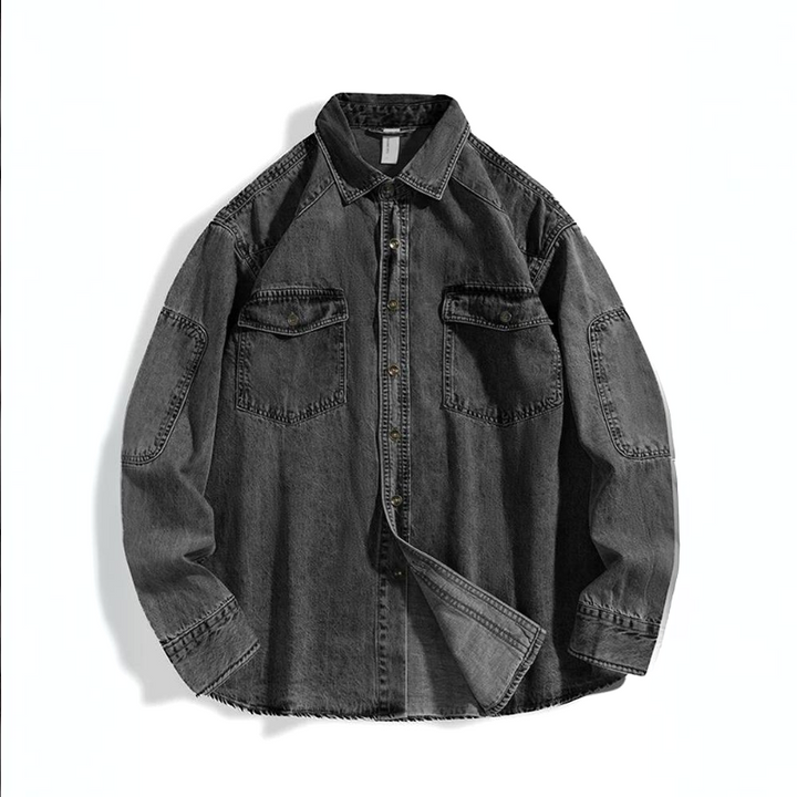 A rugged denim shirt in black pure cotton, featuring a button-up front, two chest pockets, visible stitching, long sleeves, and a classic collar, laid flat on a white background.