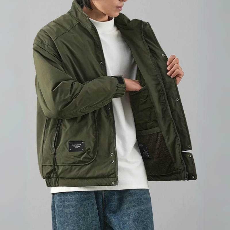 A person wearing blue jeans and a white t-shirt is opening a minimalist jacket to show its luxurious cotton lining and inner pocket. The image highlights the jacket’s details and functionality.