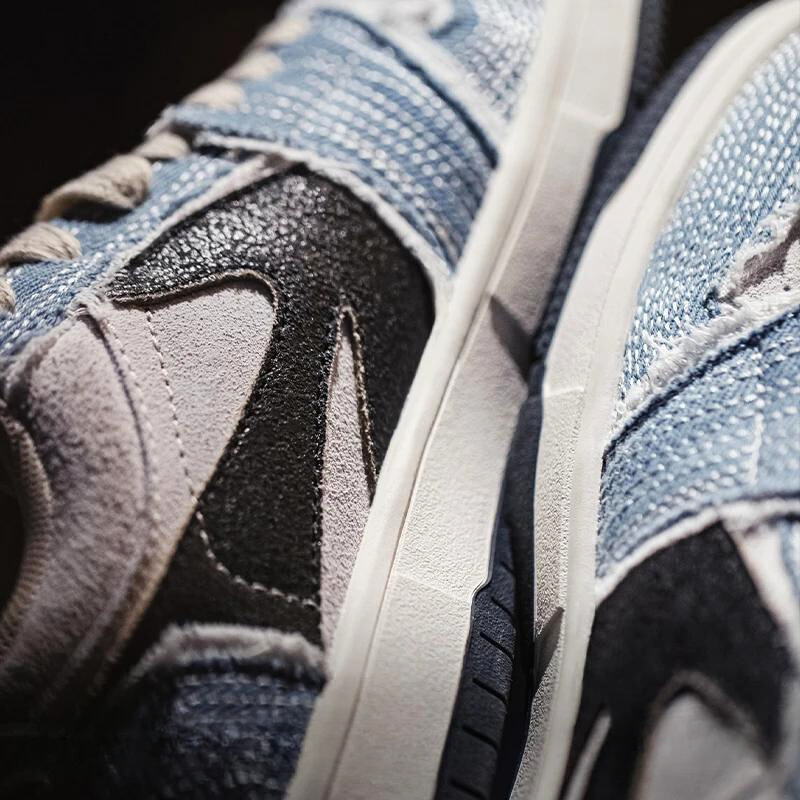 Close-up of two Denimwave 1986 Pro Sneakers with a textured mix of blue denim, black, and light gray materials, showing detailed stitching and part of the white sole for an authentic 80s aesthetic.