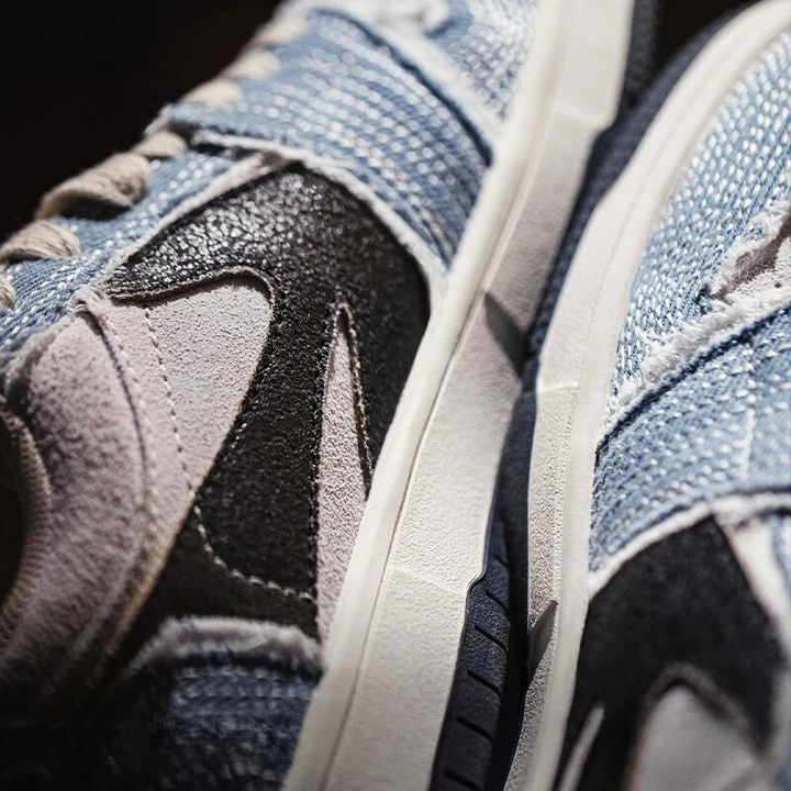 Close-up of two Denimwave 1986 Pro Sneakers with a textured mix of blue denim, black, and light gray materials, showing detailed stitching and part of the white sole for an authentic 80s aesthetic.