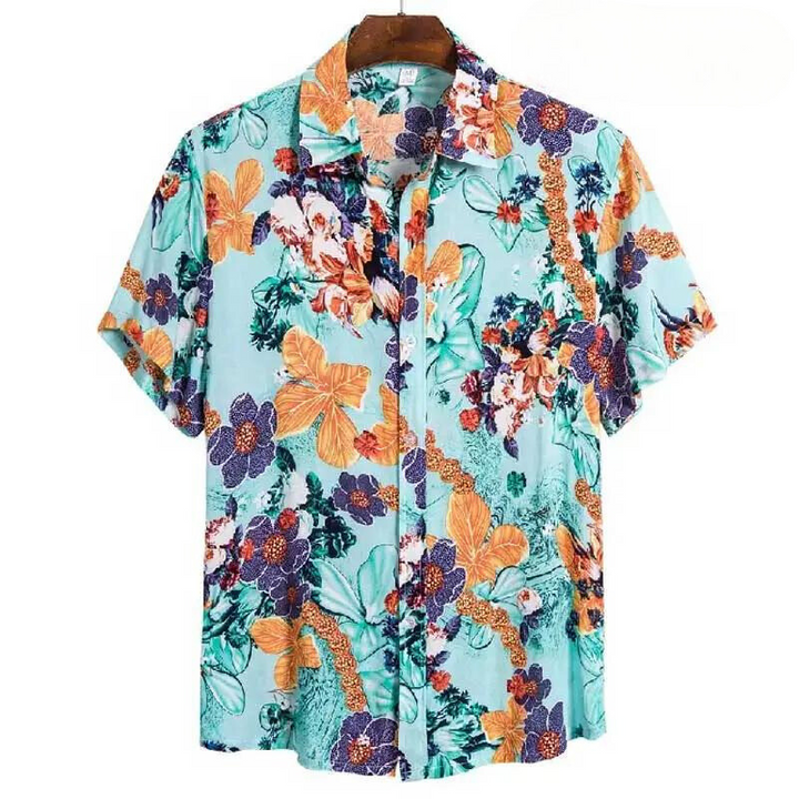 A short-sleeved, button-up floral shirt with a turquoise background, featuring a vibrant pattern in orange, purple, green, and white. Made from easy-care material, this relaxed fit shirt is displayed on a wooden hanger.