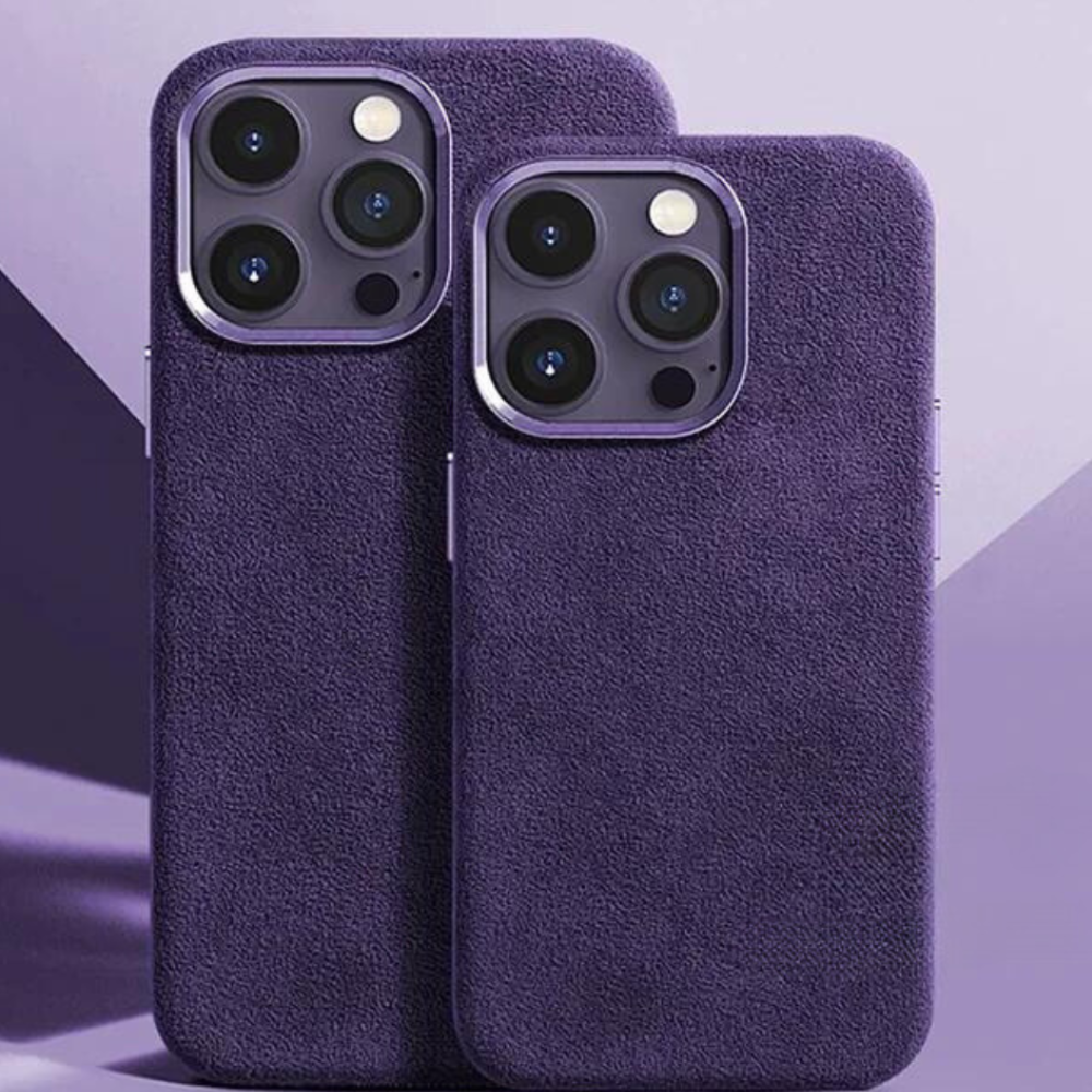 Two smartphones with triple-lens cameras are shown side by side, each in a purple alcantara phone case with a suede finish, set against a purple geometric background.