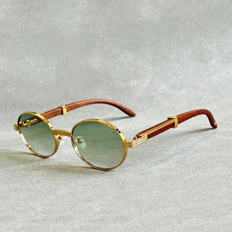 Vintage round sunglasses with gold rims, green-tinted UV400 protection lenses, and brown wooden temples are displayed on a light gray textured surface.
