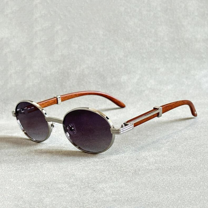Vintage round sunglasses with silver metal frames, dark tinted lenses, and wooden temples offer UV400 protection, displayed elegantly on a light gray textured surface.