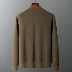 A plain, long-sleeve, olive-green merino wool sweater is displayed on a hanger against a simple gray background, shown from the back—ideal for natural temperature regulation.