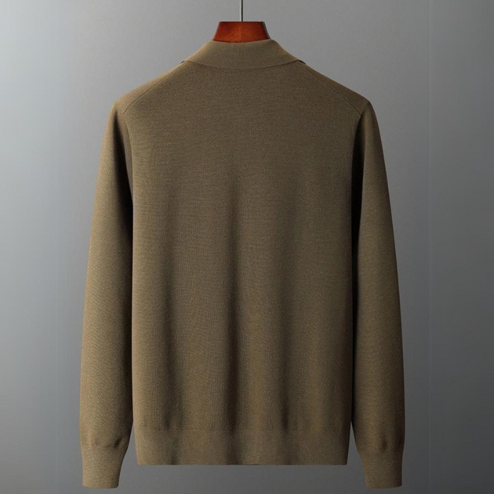 A plain, long-sleeve, olive-green merino wool sweater is displayed on a hanger against a simple gray background, shown from the back—ideal for natural temperature regulation.