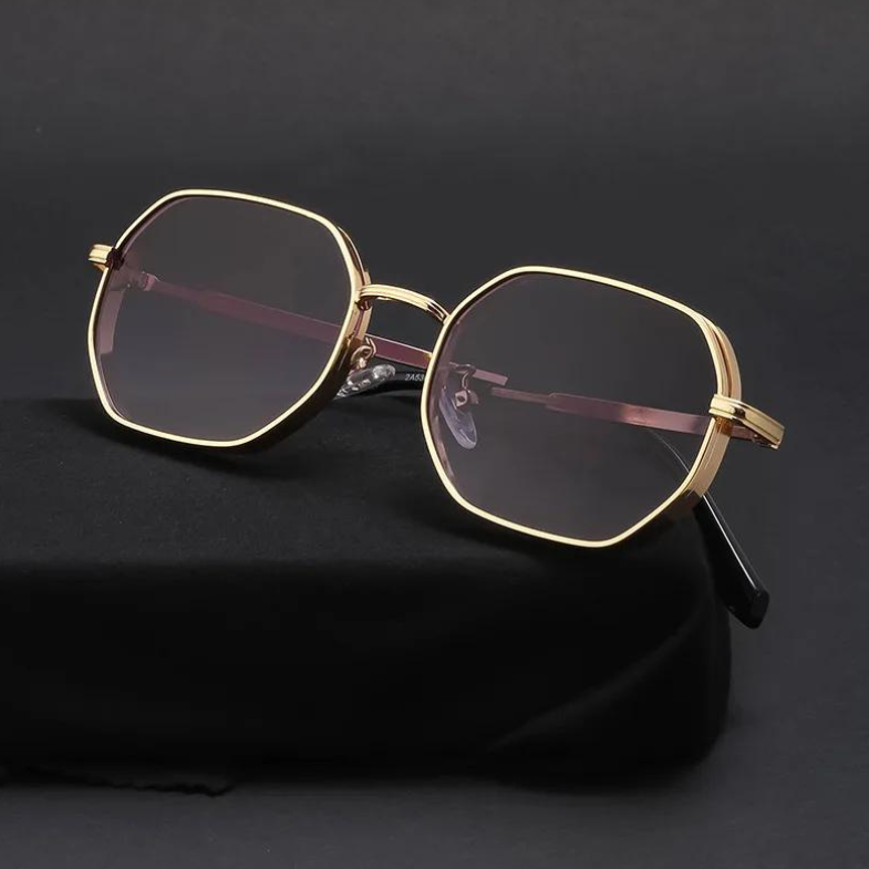 Gold-tone frames and dark tinted lenses give these geometric-shaped, vintage-inspired sunglasses a stylish edge. Displayed on black fabric against a dark background, they also offer essential UV400 protection.