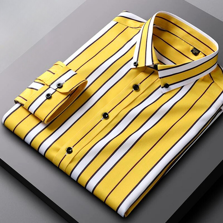 A neatly folded Hamilton Executive Classic Fit Shirt in yellow with black and white vertical stripes, black buttons, and a buttoned cuff, crafted from premium fabric and displayed on a gray surface.