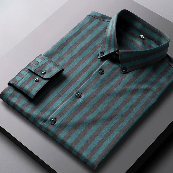 A neatly folded Hamilton Executive Classic Fit Shirt with vertical teal and black stripes, laid flat on a dark, minimalist surface. This premium fabric shirt features a button-down collar and a matching cuff—perfect for spring colors.