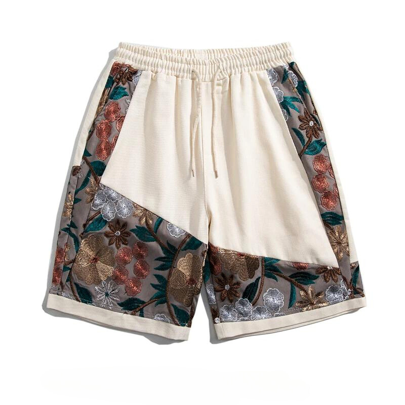 Cream-colored lightweight cotton shorts with an elastic waistband and drawstring, featuring decorative panels adorned with summer florals in brown, green, orange, silver, and gray tones.