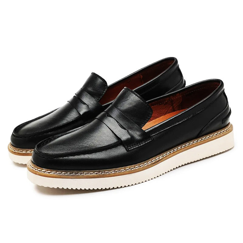 A pair of black Italian leather penny loafers with white, thick rubber soles and brown midsoles, perfect for a business casual look, displayed on a white background.