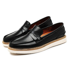A pair of black Italian leather penny loafers with white, thick rubber soles and brown midsoles, perfect for a business casual look, displayed on a white background.