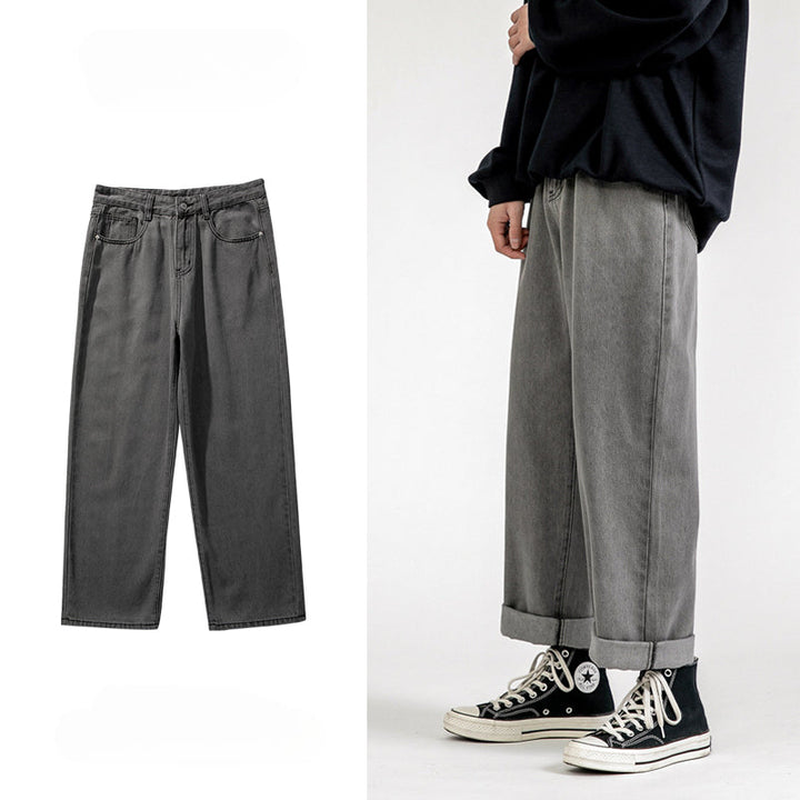 Wide-leg gray jeans with a wide-leg design are displayed flat on the left. On the right, a person wears these men’s baggy jeans cuffed at the ankle, styled with a black sweater and black high-top Converse sneakers.