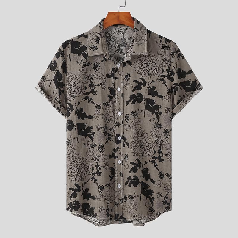 A short-sleeved, button-up Mens Hawaiian Shirt with a collar, featuring a grey background and black flower prints, displayed on a wooden hanger against a plain light grey background—a classic piece for streetwear fashion lovers.