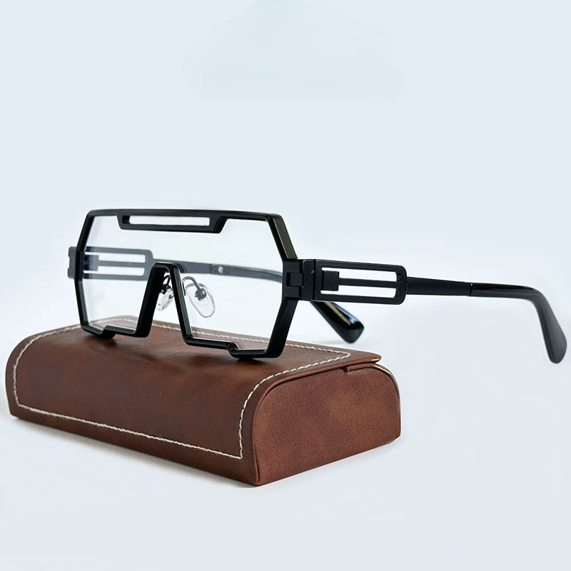 Modern, geometric eyeglasses with thick black square frames and rectangular lenses rest on a brown leather case with white stitching, set against a plain light background.